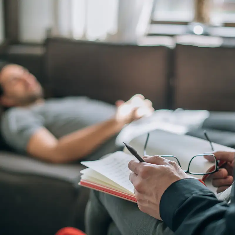 Patient liegt auf Couch bei Psychotherapeuten